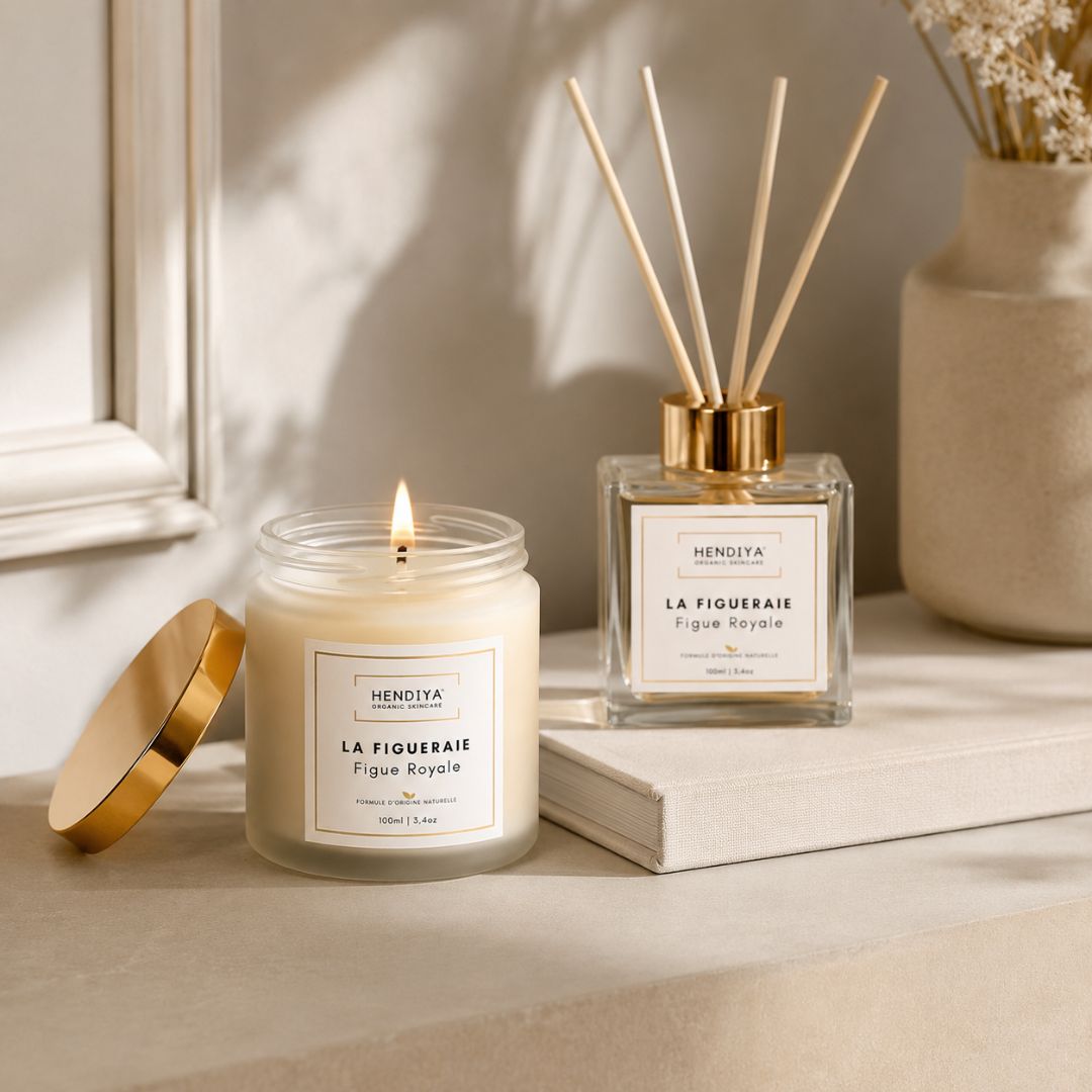 Bougie végétale et diffuseur à bâtonnets Parfum d'Ambiance Hendiya, senteur Figue Royale, posés ensemble près d'une fenêtre décorée de fleurs séchées.