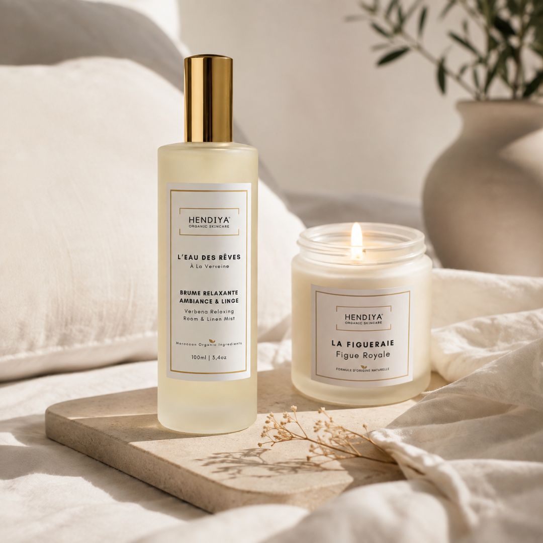 Duo du flacon de la brume relaxante L'Eau des Rêves à la verveine citronnée et de la bougie végétale La Figueraie Hendiya, posés ensemble sur un plateau avec du linge, pour une ambiance relaxante à la maison.